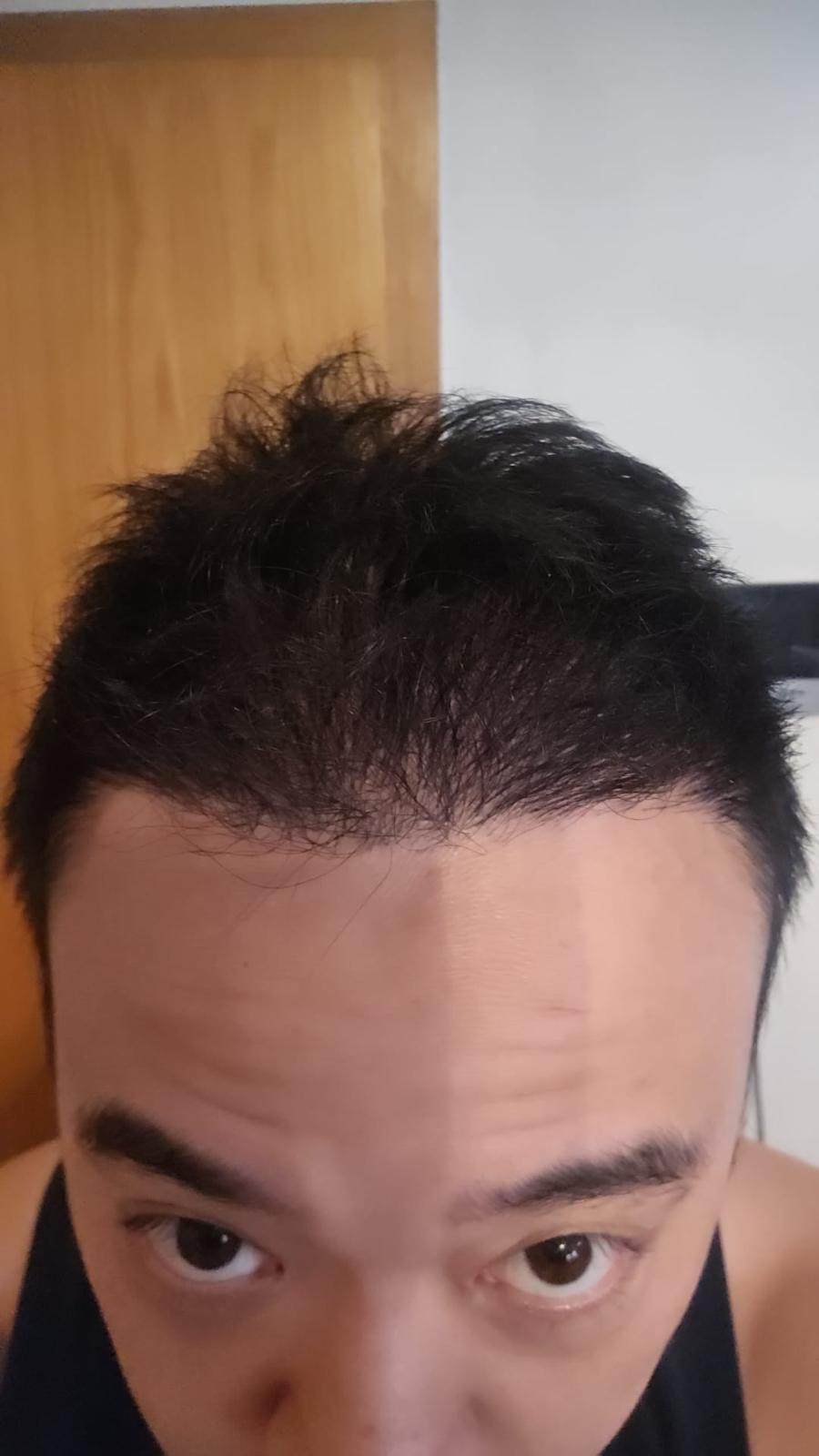 Ein Mann mit kurzen schwarzen Haaren und ernster Miene blickt nach unten